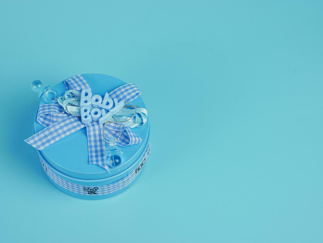 blue gift tin for baby boy isolated on blue background photo