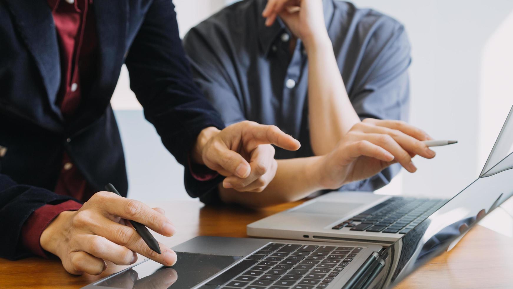 colegas asiáticos hombre y mujer discutiendo y trabajando con una computadora portátil en el escritorio de la oficina foto