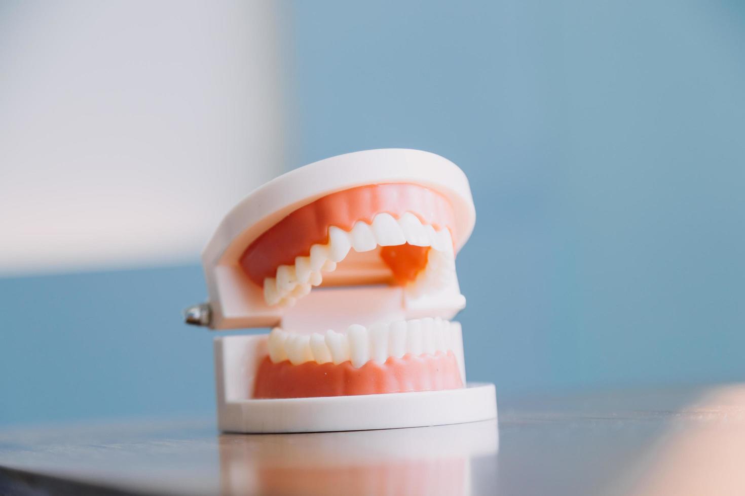 Stomatology concept, partial portrait of girl with strong white teeth looking at camera and smiling, fingers near face. Closeup of young woman at dentist's, studio, indoors photo