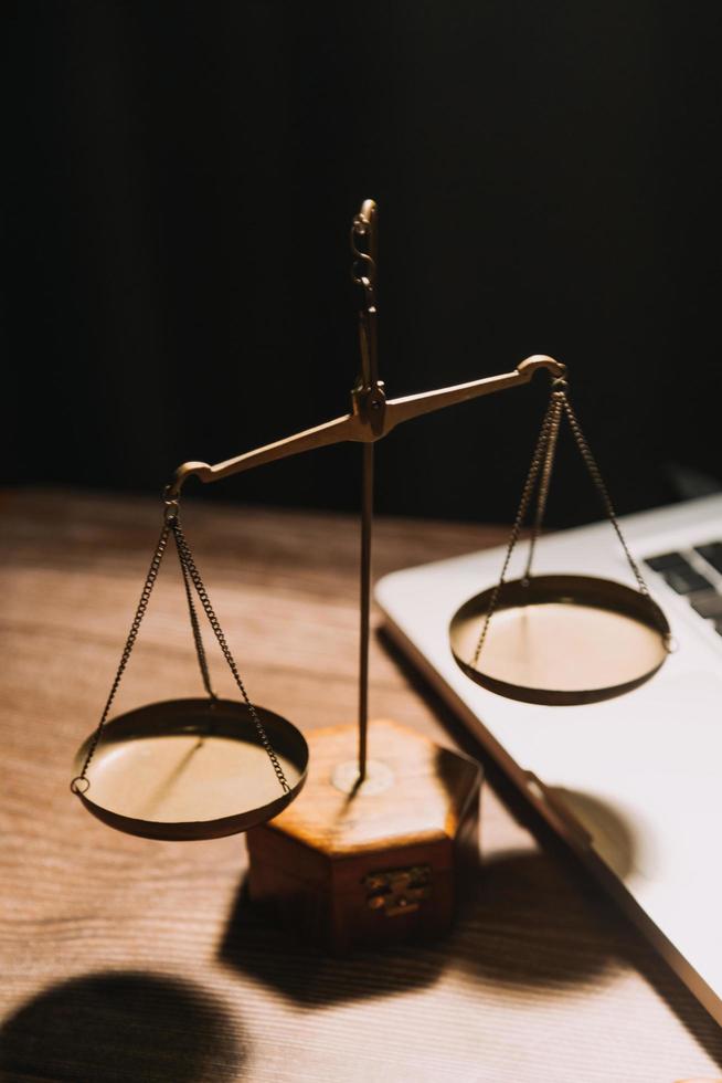 Business and lawyers discussing contract papers with brass scale on desk in office. Law, legal services, advice, justice and law concept picture with film grain effect photo