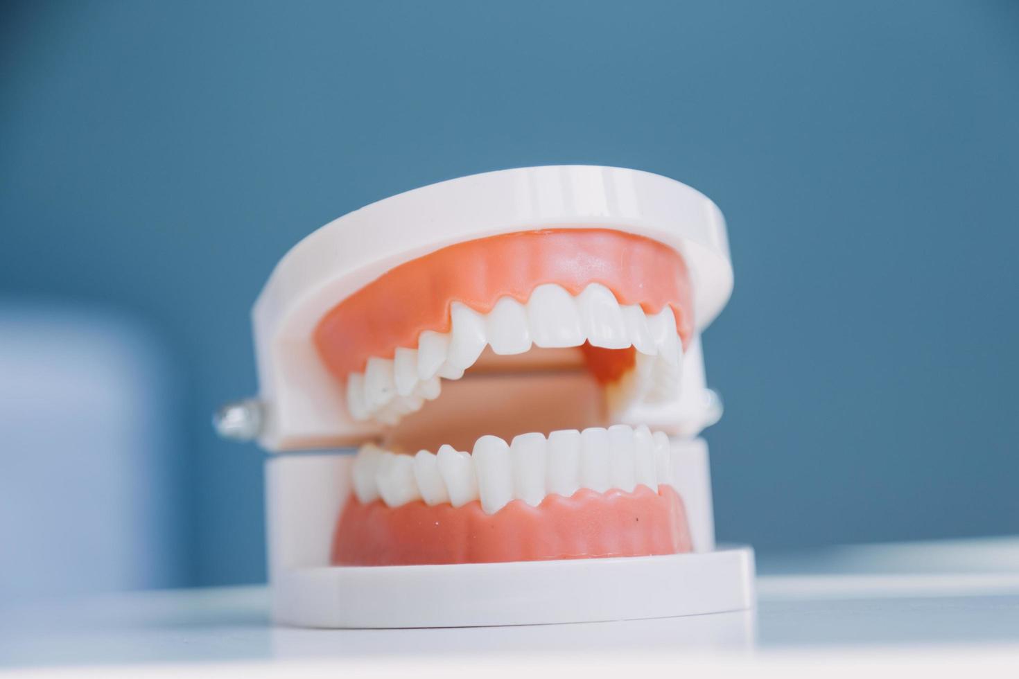 Stomatology concept, partial portrait of girl with strong white teeth looking at camera and smiling, fingers near face. Closeup of young woman at dentist's, studio, indoors photo