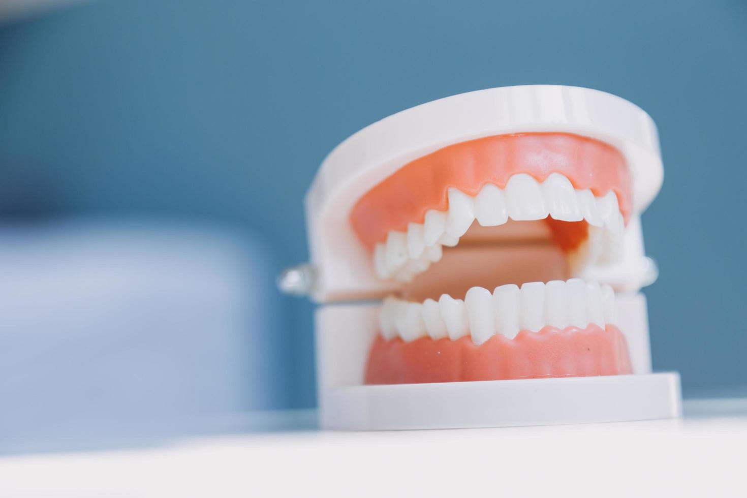 Stomatology concept, partial portrait of girl with strong white teeth looking at camera and smiling, fingers near face. Closeup of young woman at dentist's, studio, indoors photo