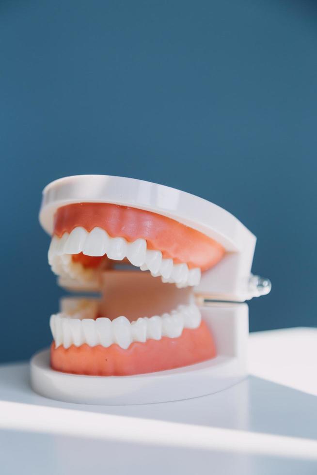 Stomatology concept, partial portrait of girl with strong white teeth looking at camera and smiling, fingers near face. Closeup of young woman at dentist's, studio, indoors photo