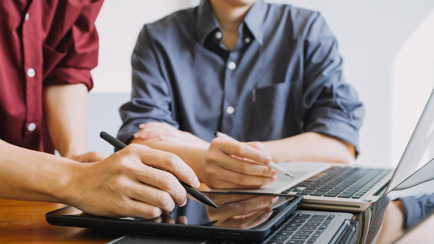 colegas asiáticos hombre y mujer discutiendo y trabajando con una computadora portátil en el escritorio de la oficina foto