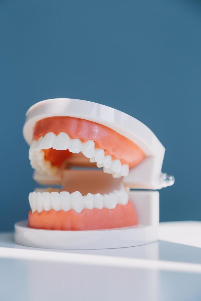 Stomatology concept, partial portrait of girl with strong white teeth looking at camera and smiling, fingers near face. Closeup of young woman at dentist's, studio, indoors photo