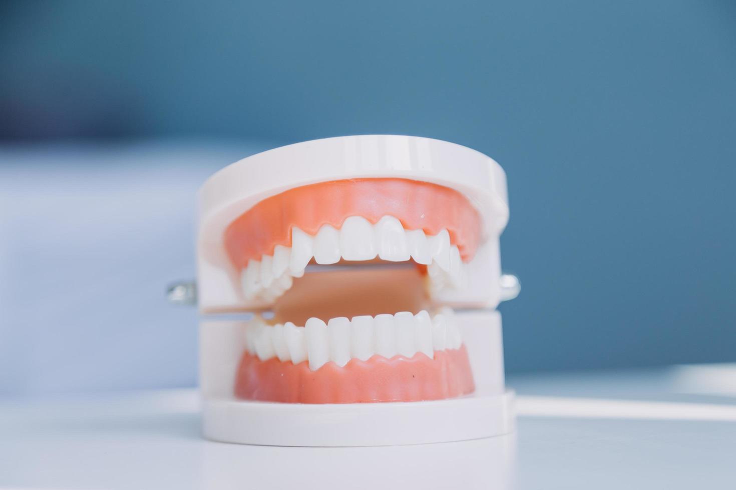 Stomatology concept, partial portrait of girl with strong white teeth looking at camera and smiling, fingers near face. Closeup of young woman at dentist's, studio, indoors photo