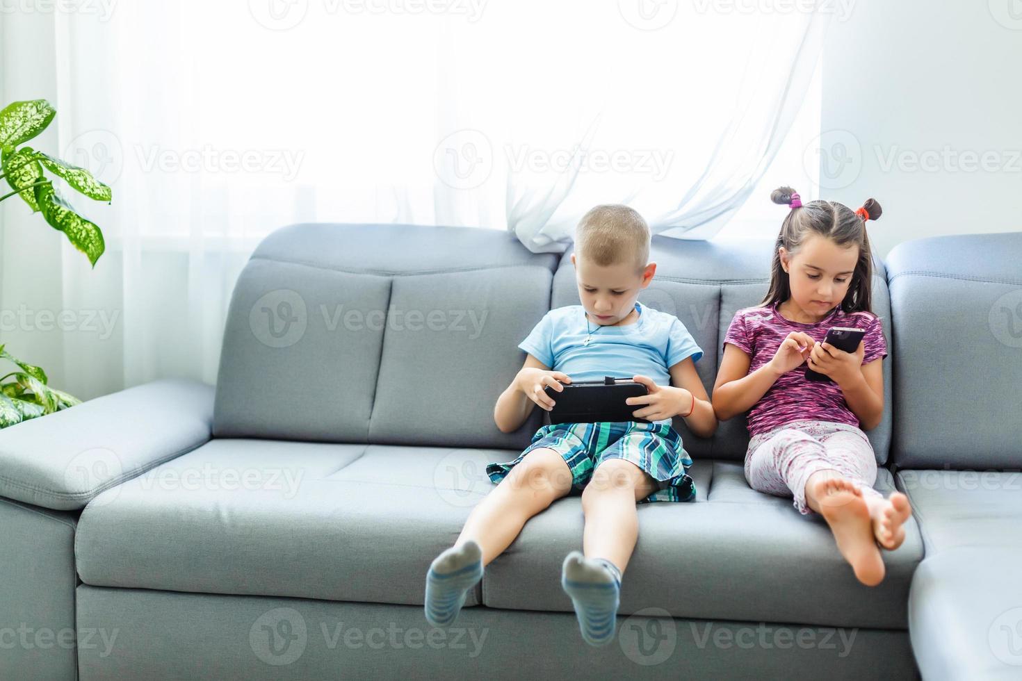 niños en edad preescolar jugando en el teléfono inteligente foto