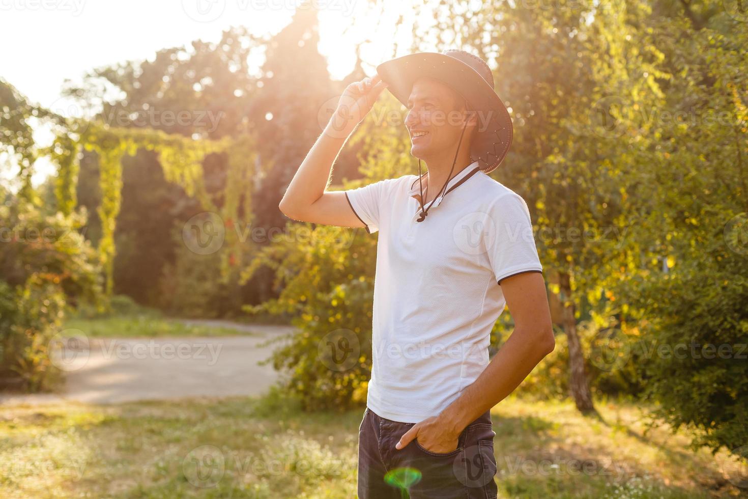A man wearing a cowboy hat, jeans and a belt. photo