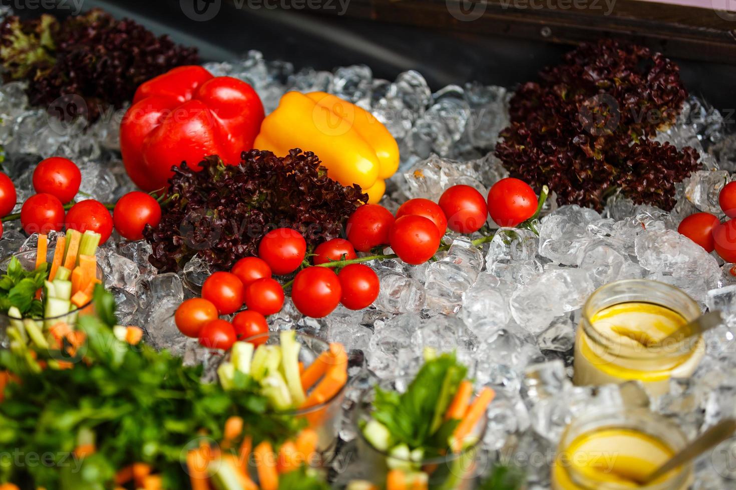 Small red cherry tomatoes spill out of a wicker basket on an old wooden table in rustic style, selective focus photo