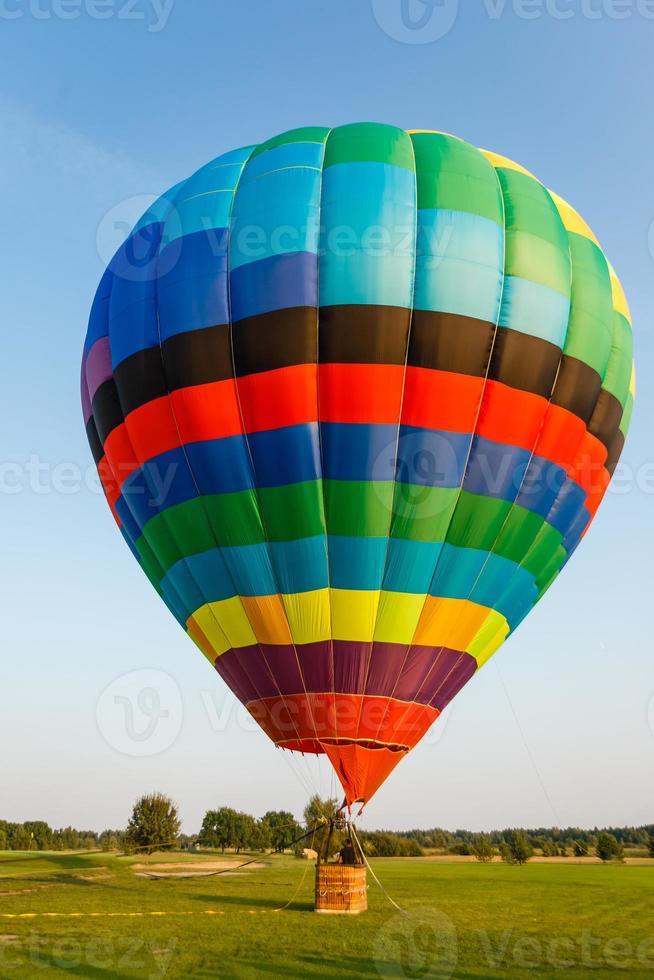 Hot air balloon over the field with blue sky photo