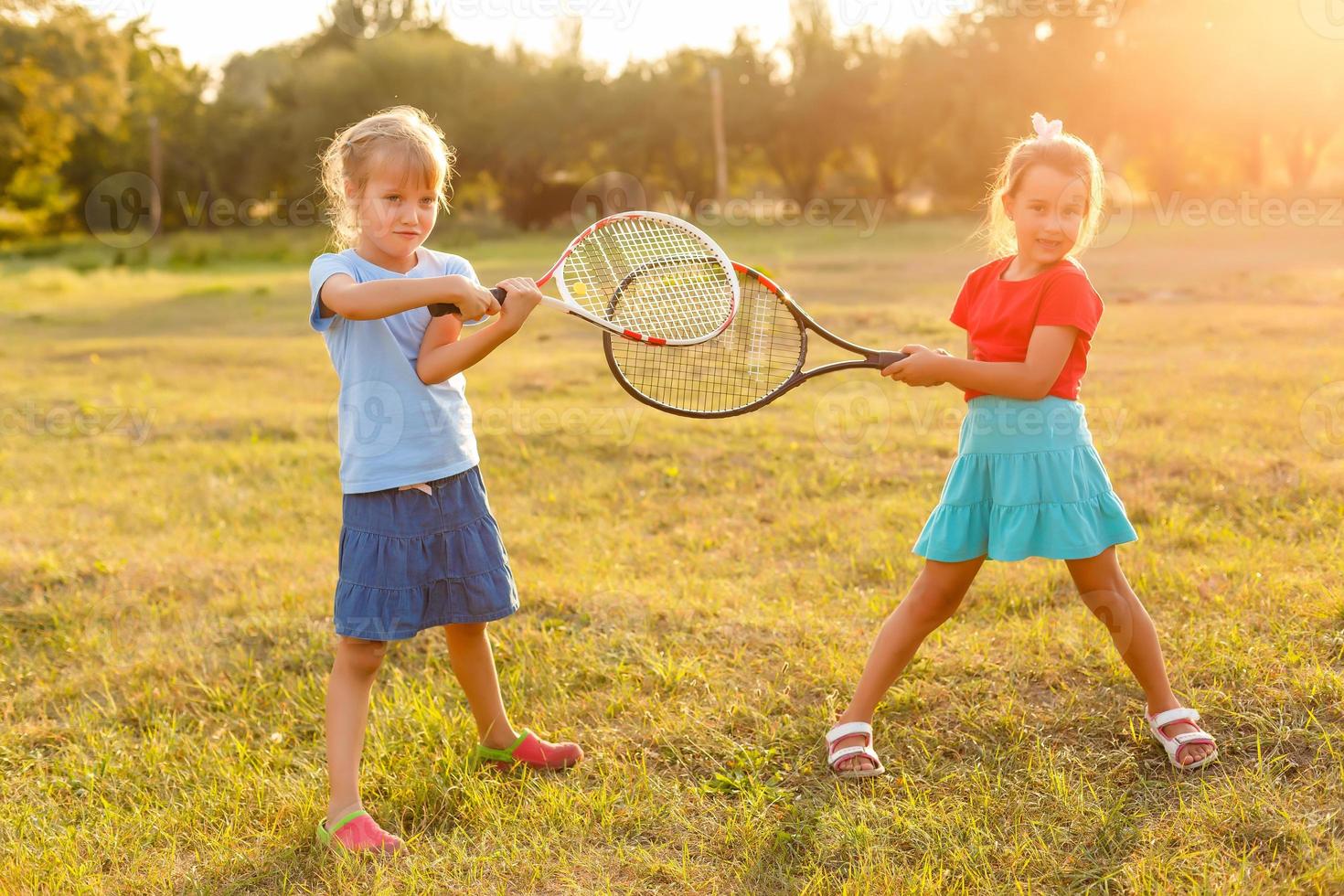 two little girls with tennis rackets photo