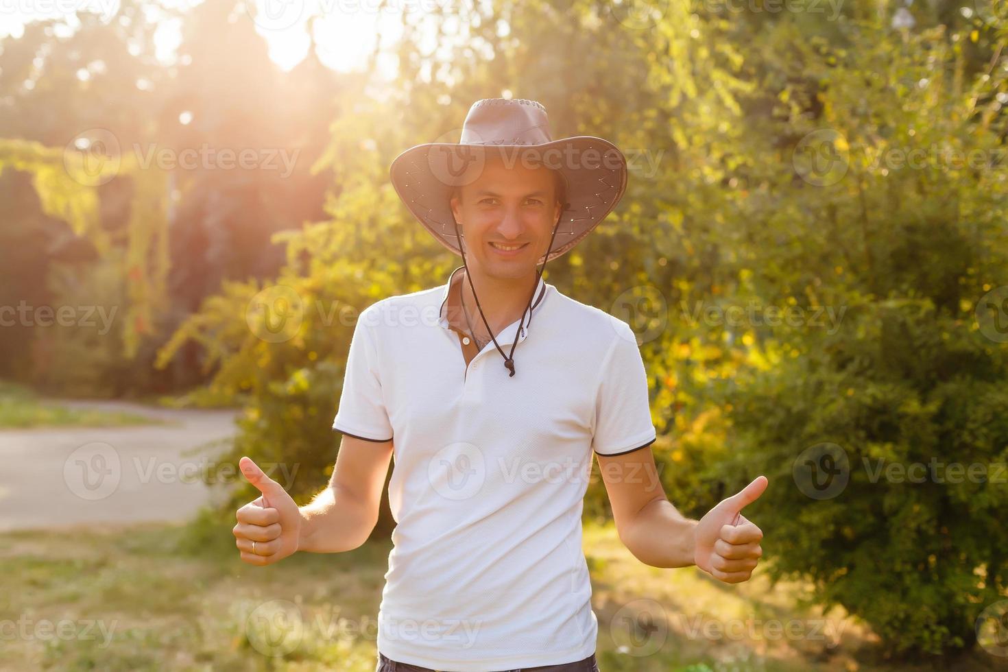 A man wearing a cowboy hat, jeans and a belt. photo