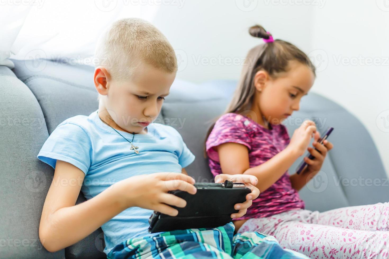niños en edad preescolar jugando en el teléfono inteligente foto