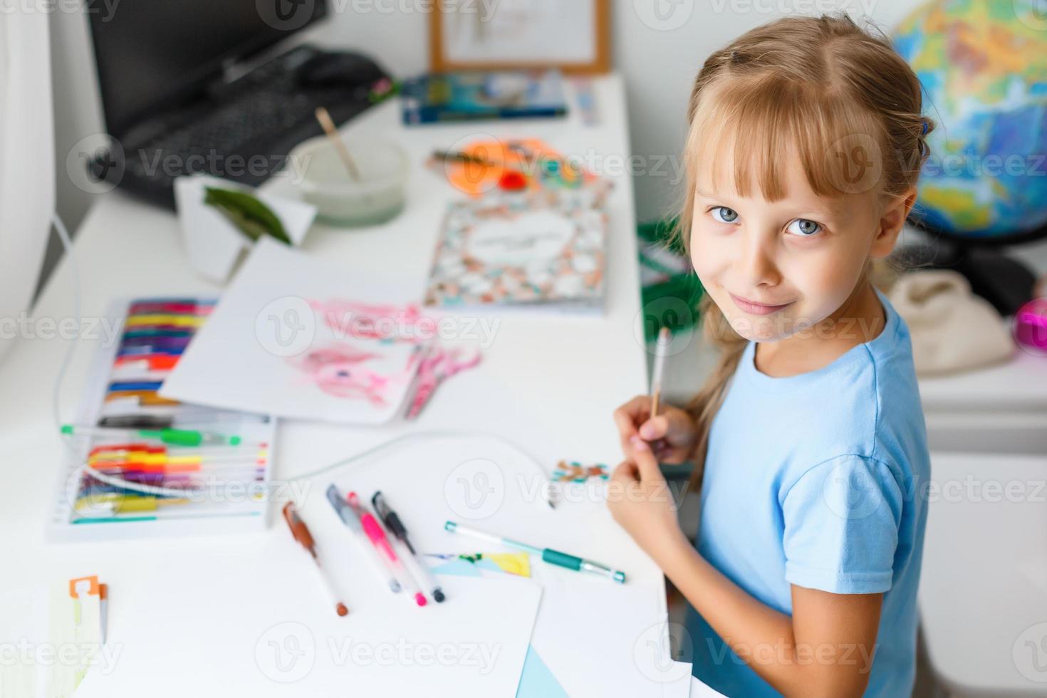 education, creation and school concept - smiling little student girl drawing and daydreaming at school photo