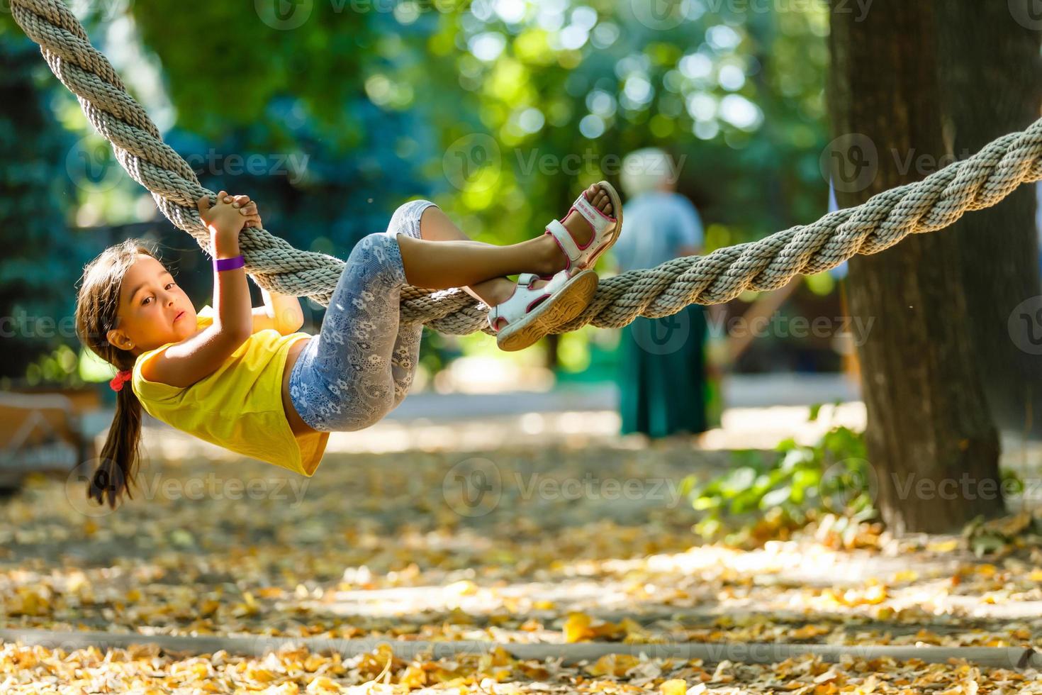Little girl swinging on a rope photo