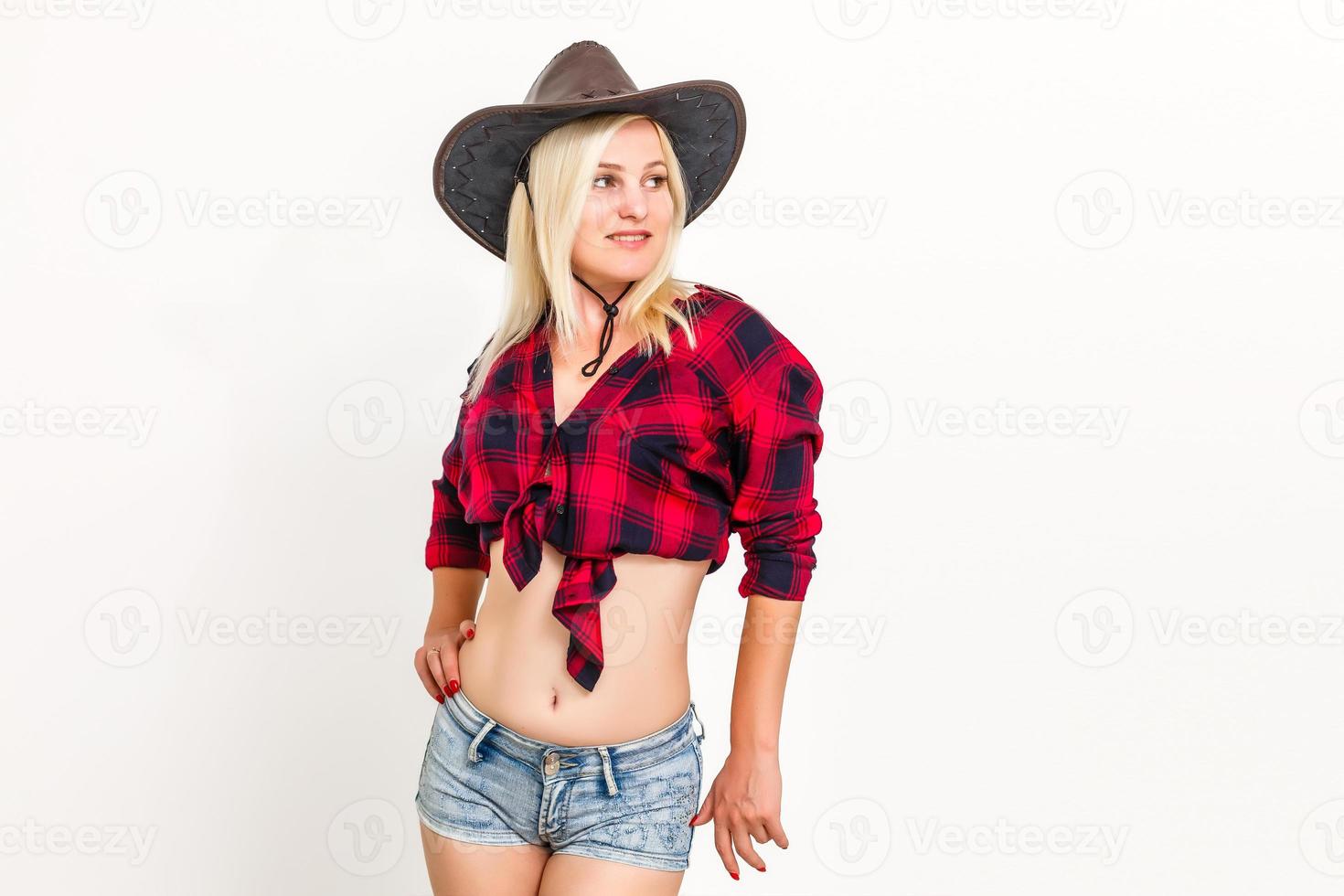 la mujer rubia sexy con un sombrero vaquero mujer sobre un fondo blanco foto