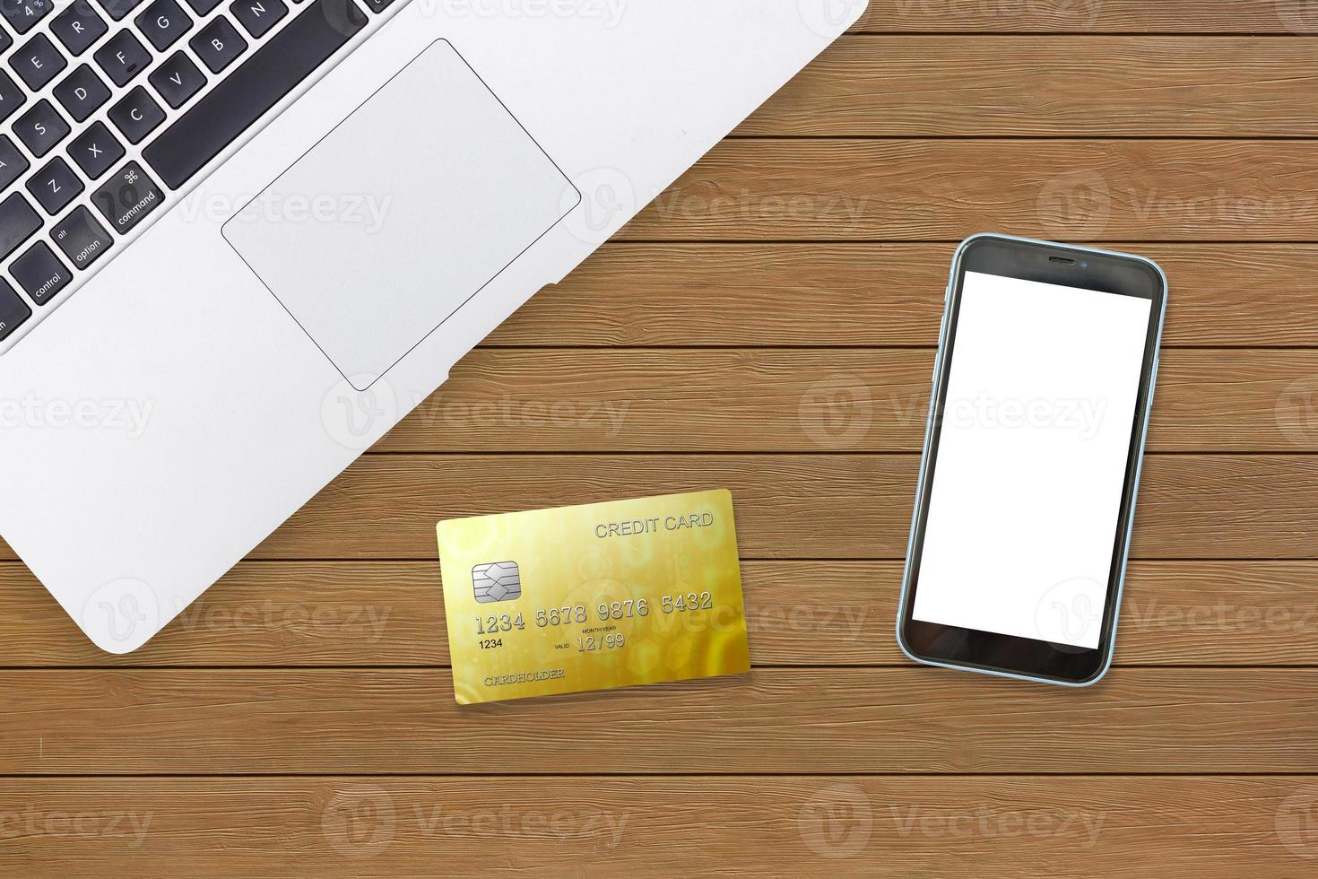 Laptop with mobile phone, credit cards light wooden table photo