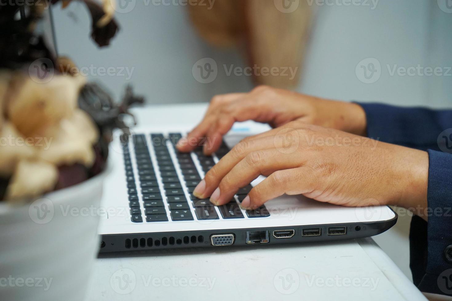 imagen de las manos de un hombre de negocios asiático trabajando en la oficina con una computadora portátil, escribiendo en el teclado en su escritorio, cerrar foto