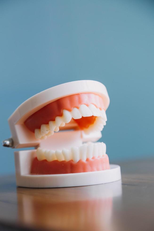 Stomatology concept, partial portrait of girl with strong white teeth looking at camera and smiling, fingers near face. Closeup of young woman at dentist's, studio, indoors photo