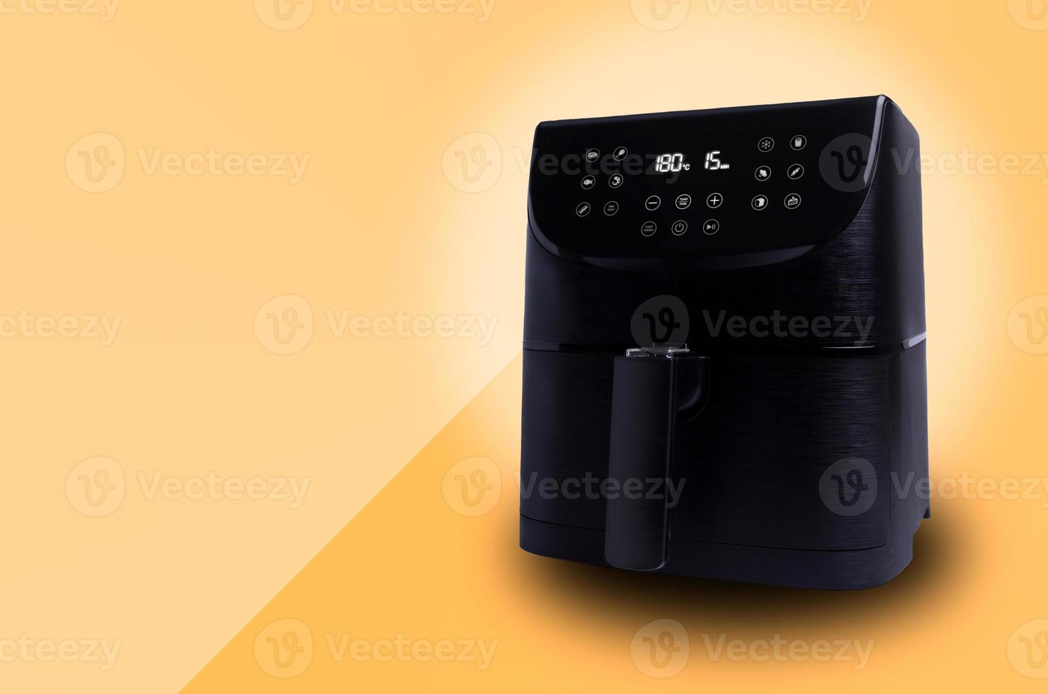 Air Fryer isolated on light orange background with copy space. Small household appliance for healthy food. photo