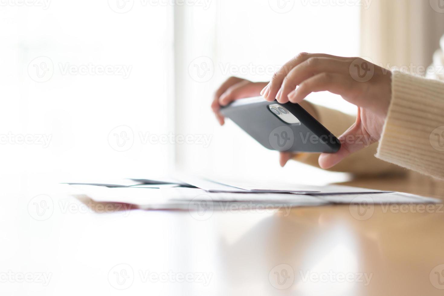 Woman paying bills using mobile phone. Cashless payment concept. photo