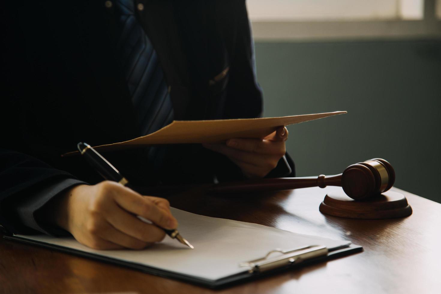 Business and lawyers discussing contract papers with brass scale on desk in office. Law, legal services, advice, justice and law concept picture with film grain effect photo