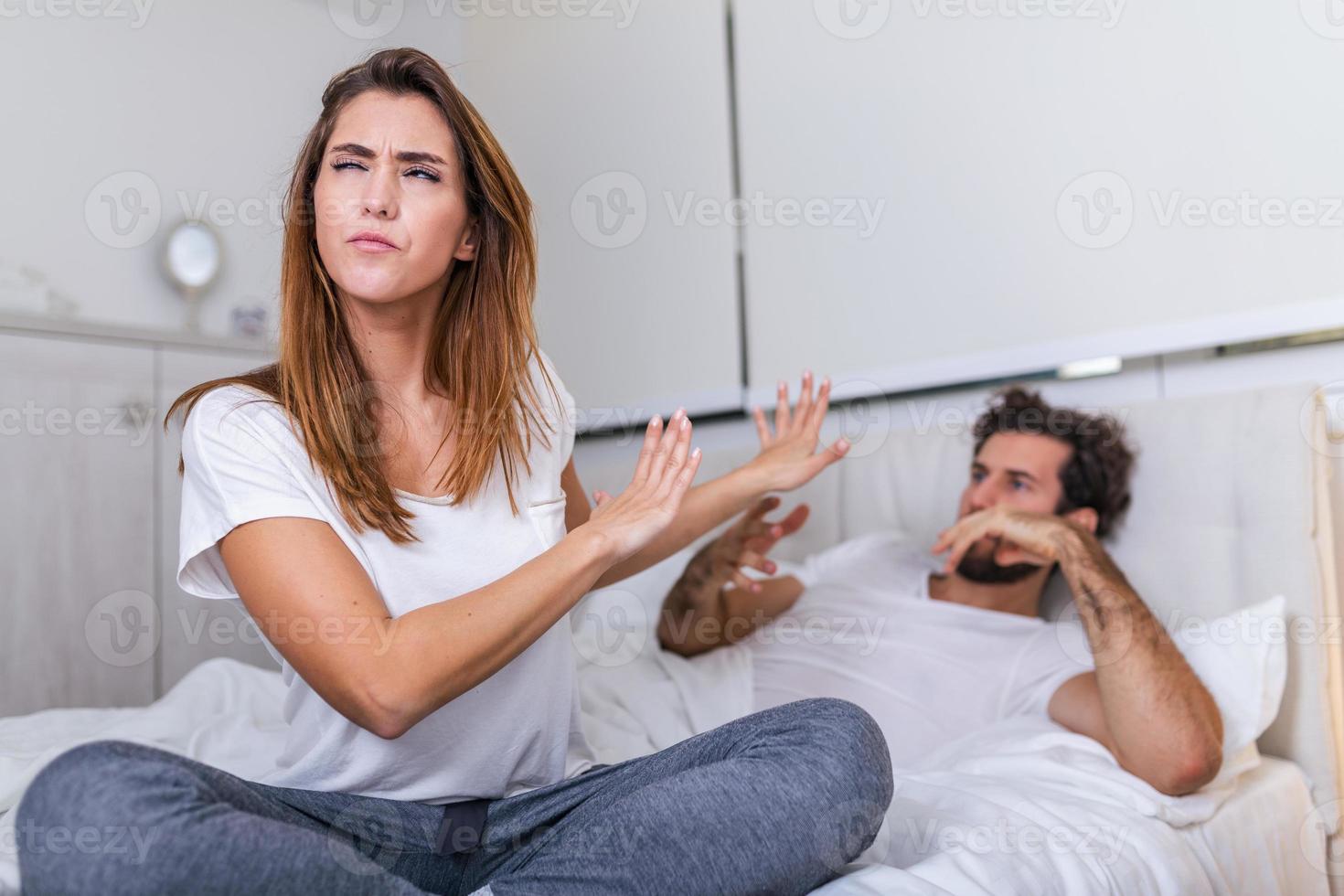 Couple With Problems Having Disagreement In Bed. Frustrated couple arguing and having marriage problems, Young couple into an argument on bed in bedroom photo
