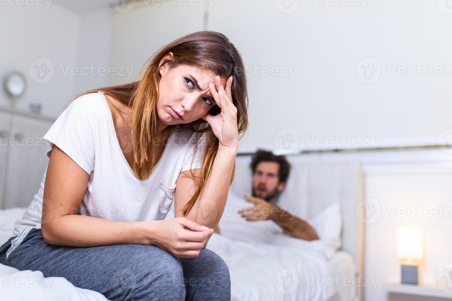 Frustrated sad girlfriend sit on bed think of relationship problems, thoughtful couple after quarrel lost in thoughts, upset lovers consider break up, offended person disappointed by boyfriend photo