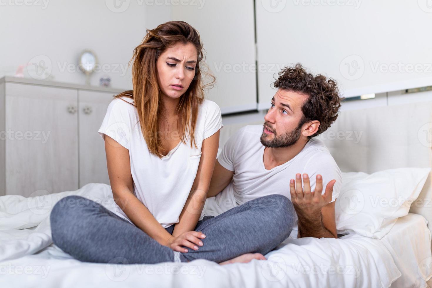 Frustrated sad girlfriend sit on bed think of relationship problems, thoughtful couple after quarrel lost in thoughts, upset lovers consider break up, offended person disappointed by boyfriend photo