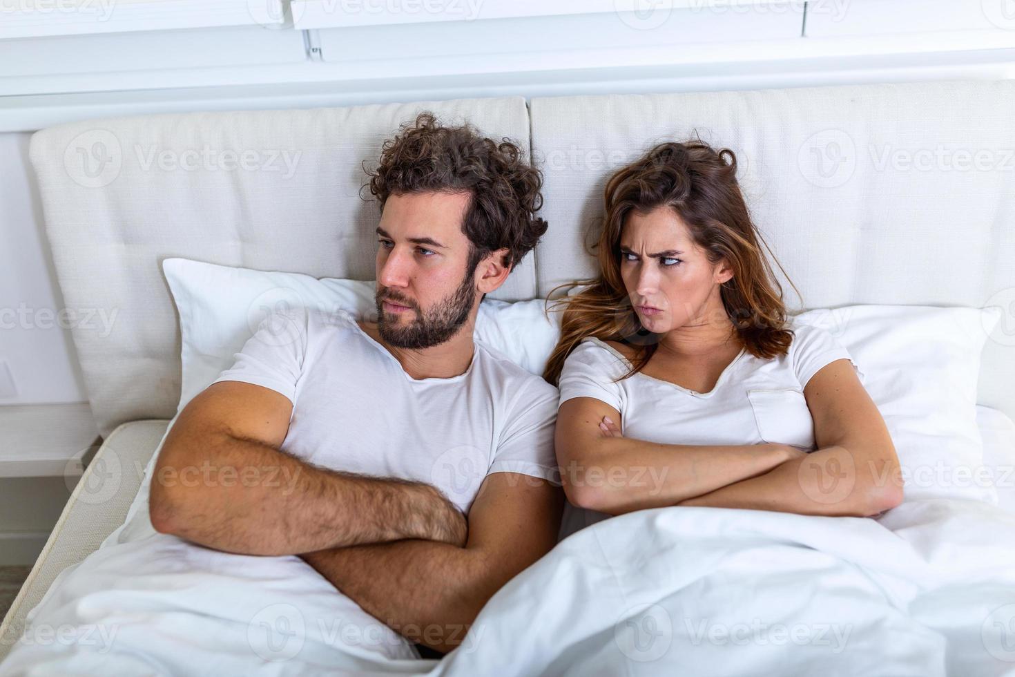 Relationship concept. Top view of young couple lying on the bed. Couple having a fight in the bed. concept about relationship and problems between couples. Sexual frustration. Lovers ignore each other photo