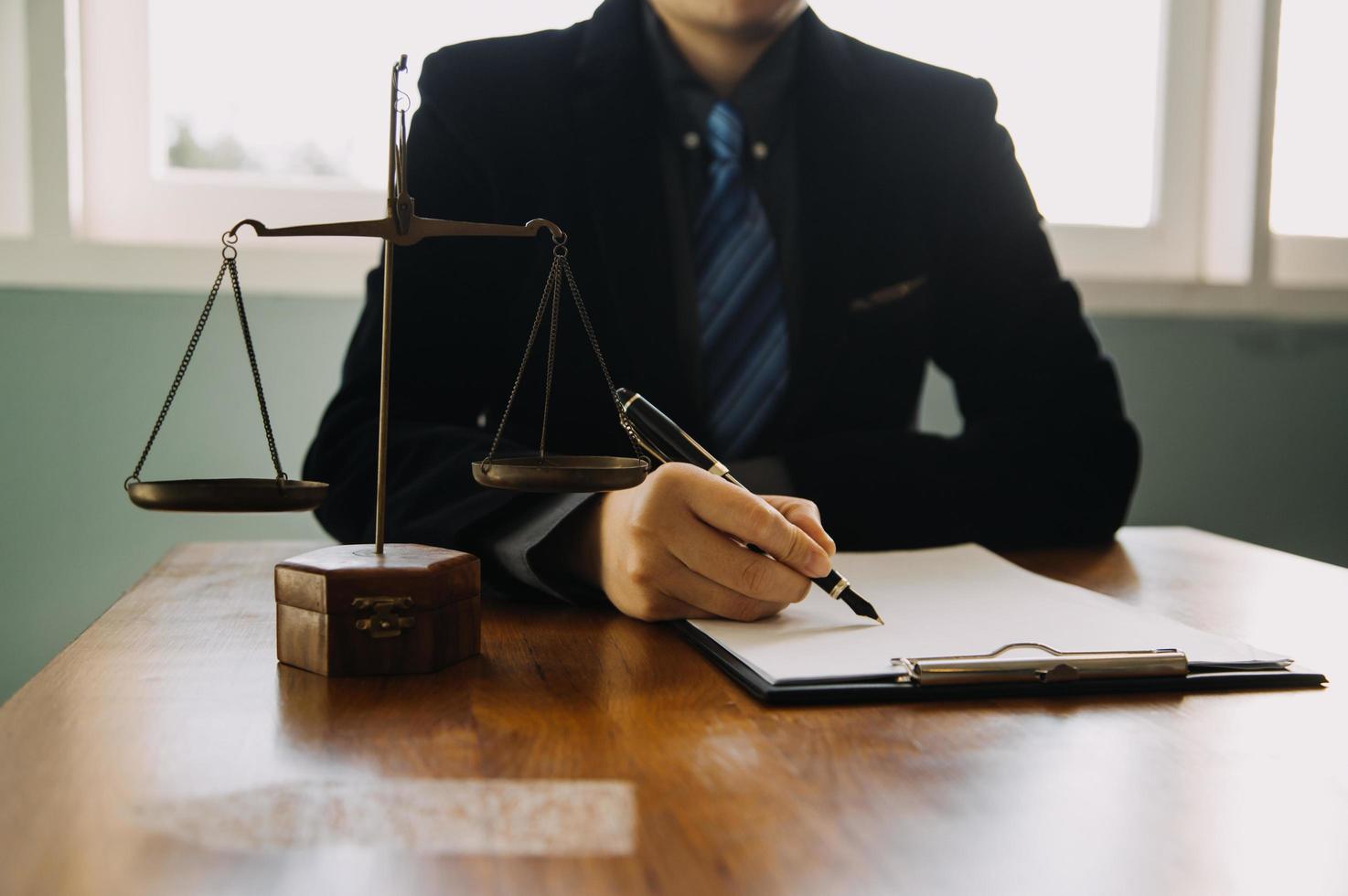 Business and lawyers discussing contract papers with brass scale on desk in office. Law, legal services, advice, justice and law concept picture with film grain effect photo