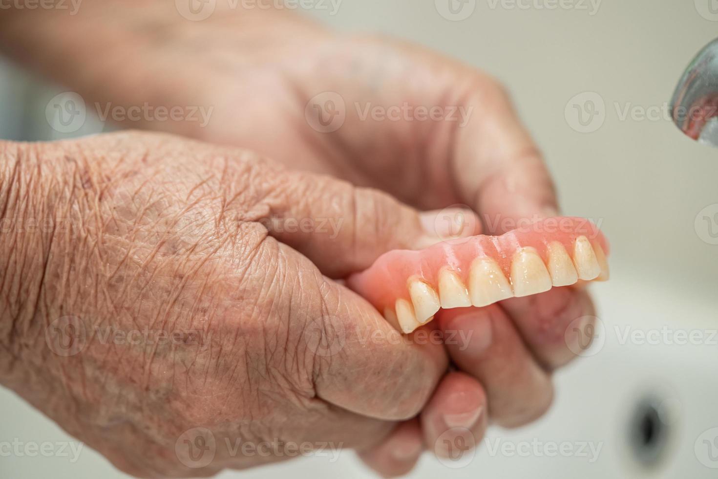 Asian senior old woman patient holding and washing denture in nursing hospital ward healthy strong medical concept photo