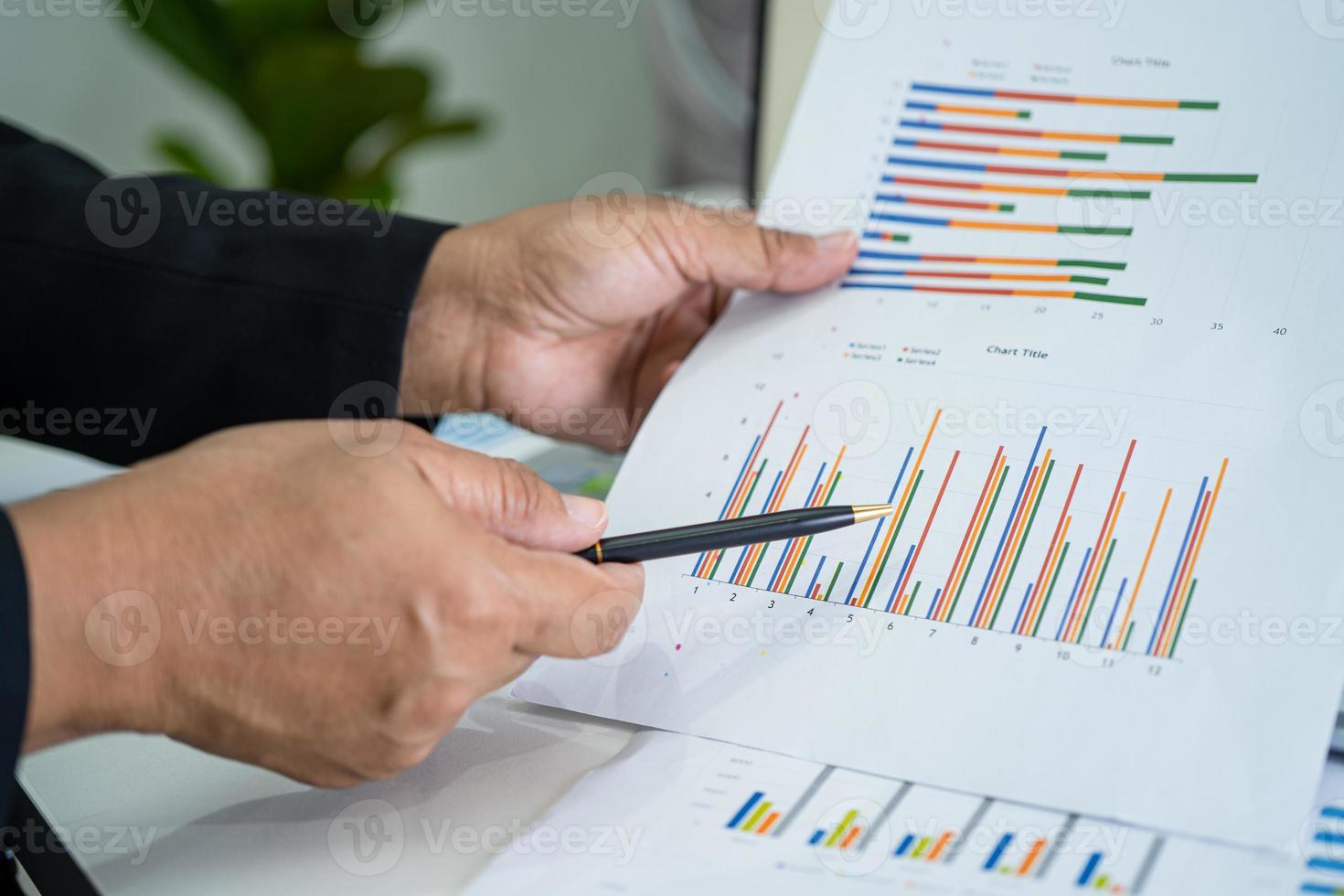 Asian accountant working and analyzing financial reports project accounting with chart graph and calculator in modern office, finance and business concept. photo