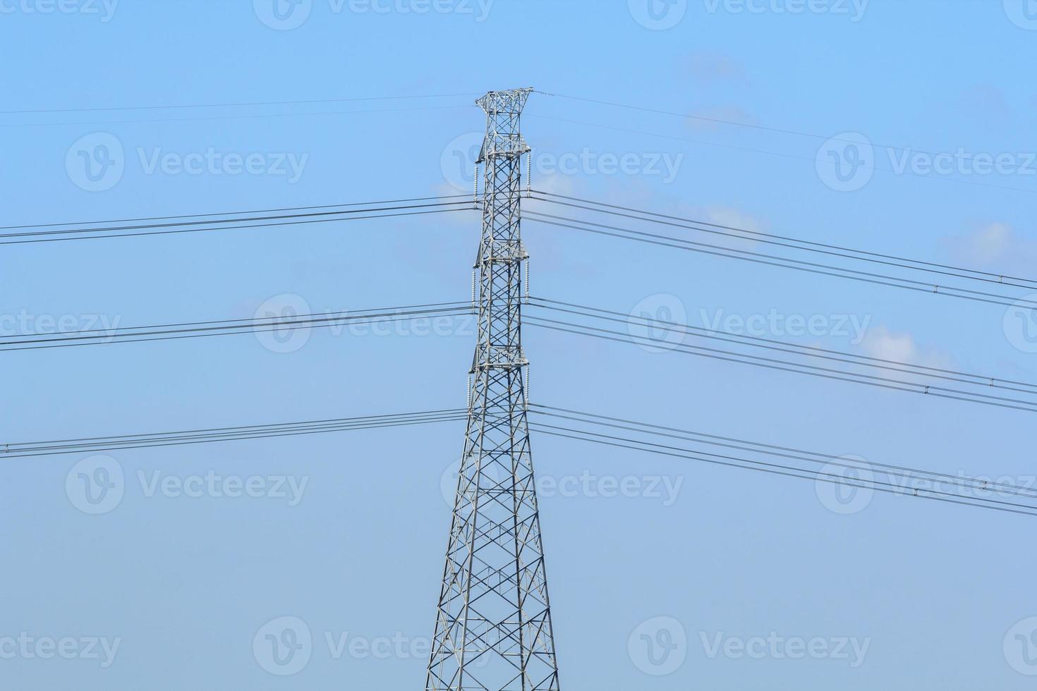 High Voltage Poles - Long-term lakeside high-voltage poles are being built by experienced engineers to provide people with electricity and consumer services. photo