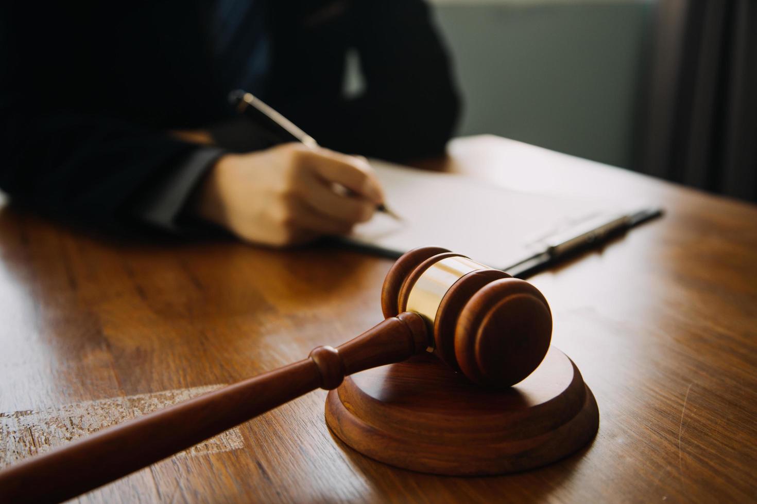 Business and lawyers discussing contract papers with brass scale on desk in office. Law, legal services, advice, justice and law concept picture with film grain effect photo