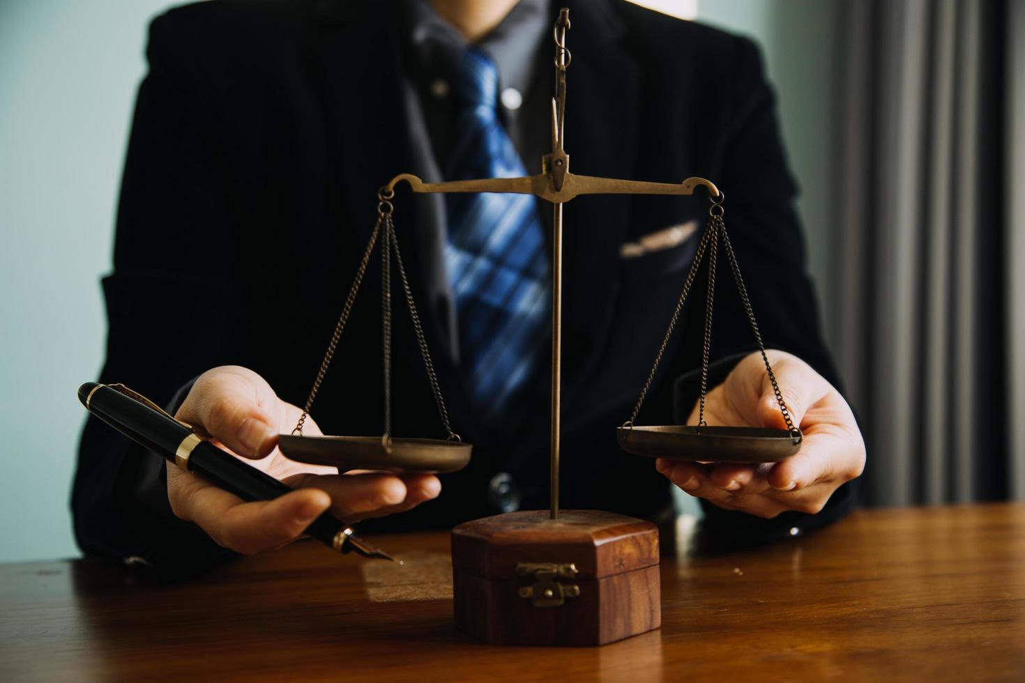 Business and lawyers discussing contract papers with brass scale on desk in office. Law, legal services, advice, justice and law concept picture with film grain effect photo
