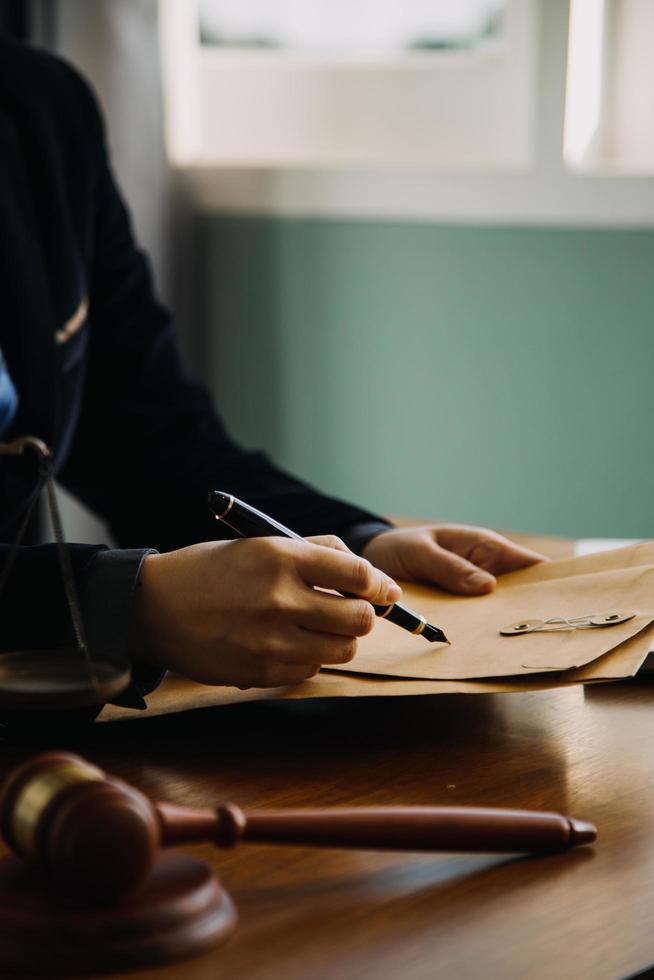 Business and lawyers discussing contract papers with brass scale on desk in office. Law, legal services, advice, justice and law concept picture with film grain effect photo