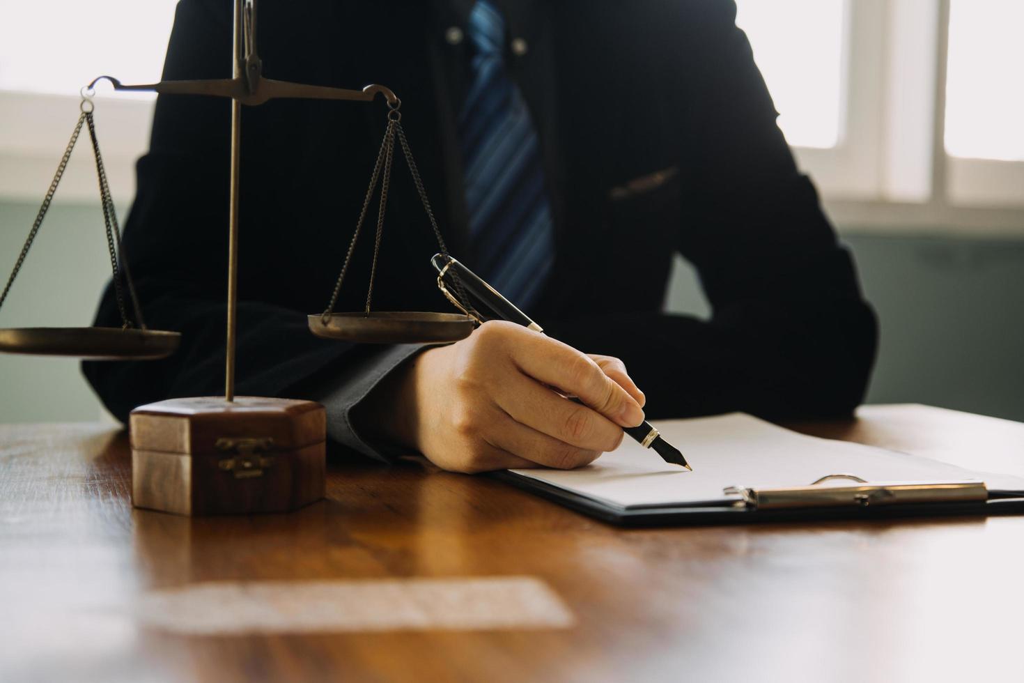 Business and lawyers discussing contract papers with brass scale on desk in office. Law, legal services, advice, justice and law concept picture with film grain effect photo