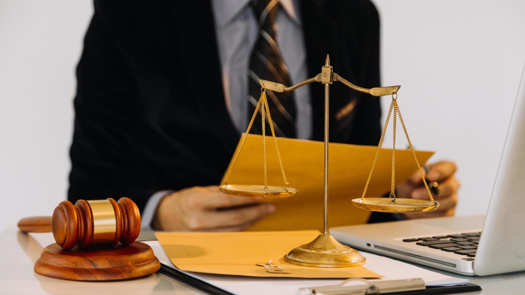 Business and lawyers discussing contract papers with brass scale on desk in office. Law, legal services, advice, justice and law concept photo