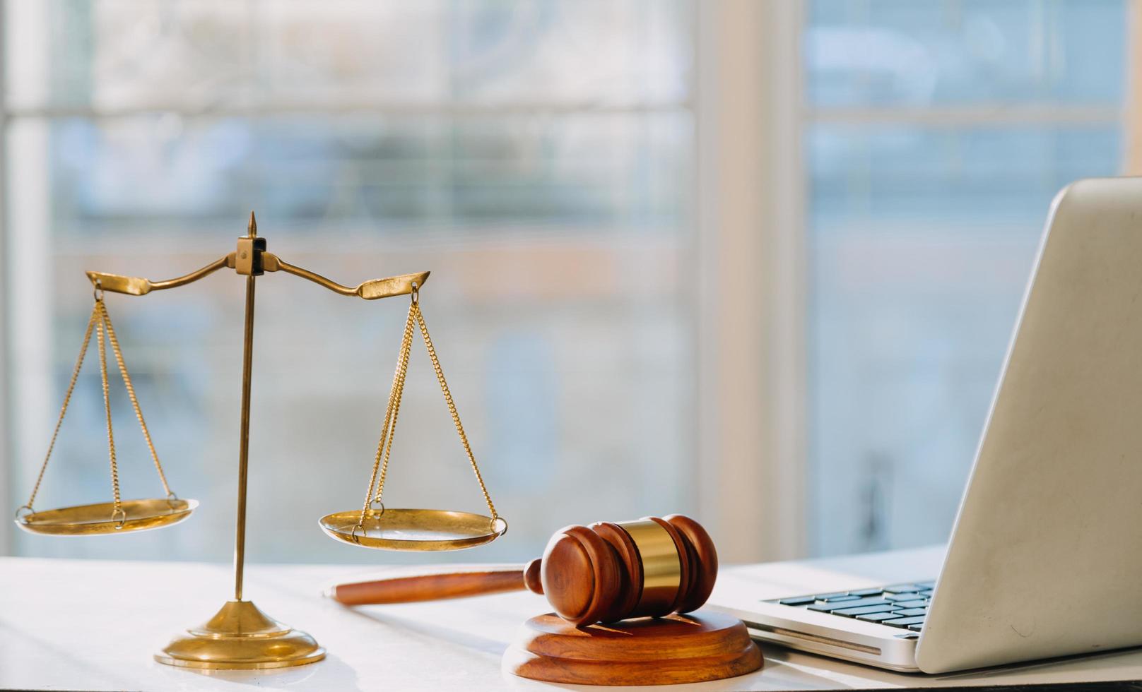 Business and lawyers discussing contract papers with brass scale on desk in office. Law, legal services, advice, justice and law concept photo