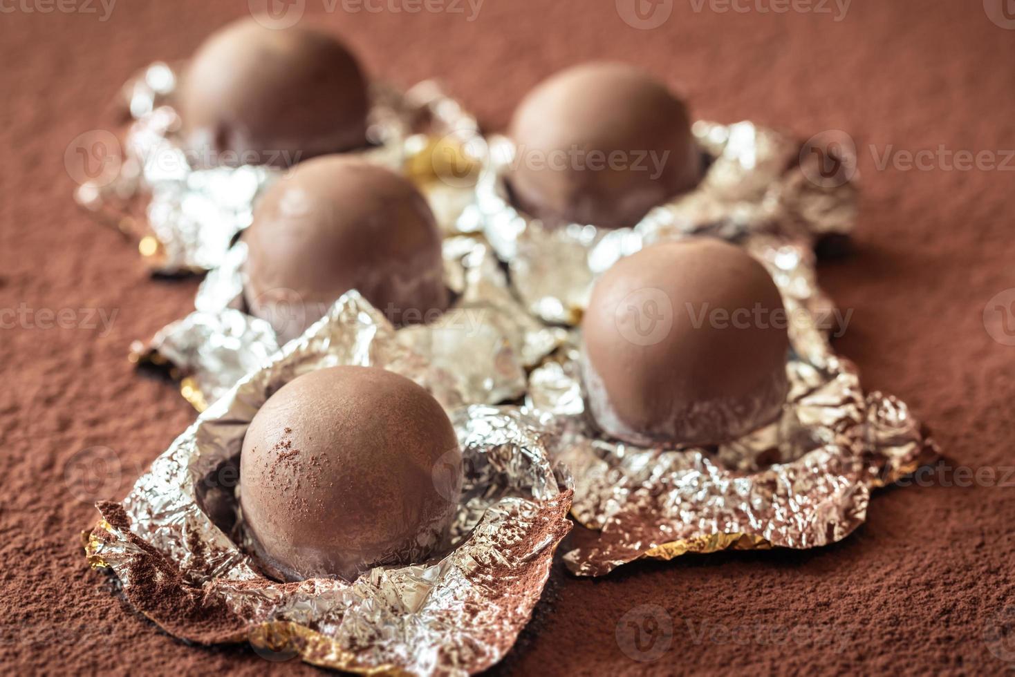 Chocolate truffles on cocoa background photo