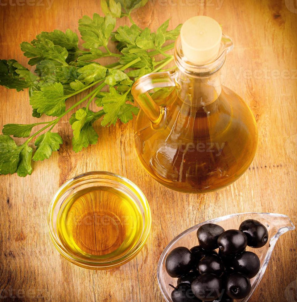 olives and olive oil on wooden table photo