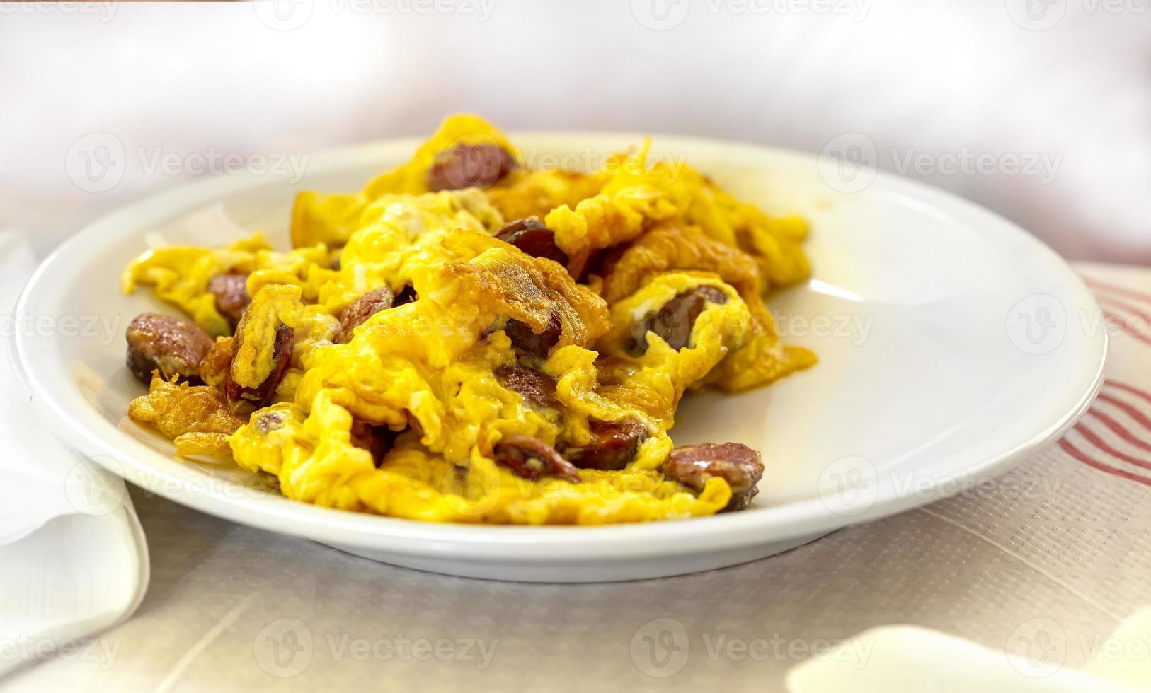 delicious omelet with sausage cooked on a white plate in a restaurant photo