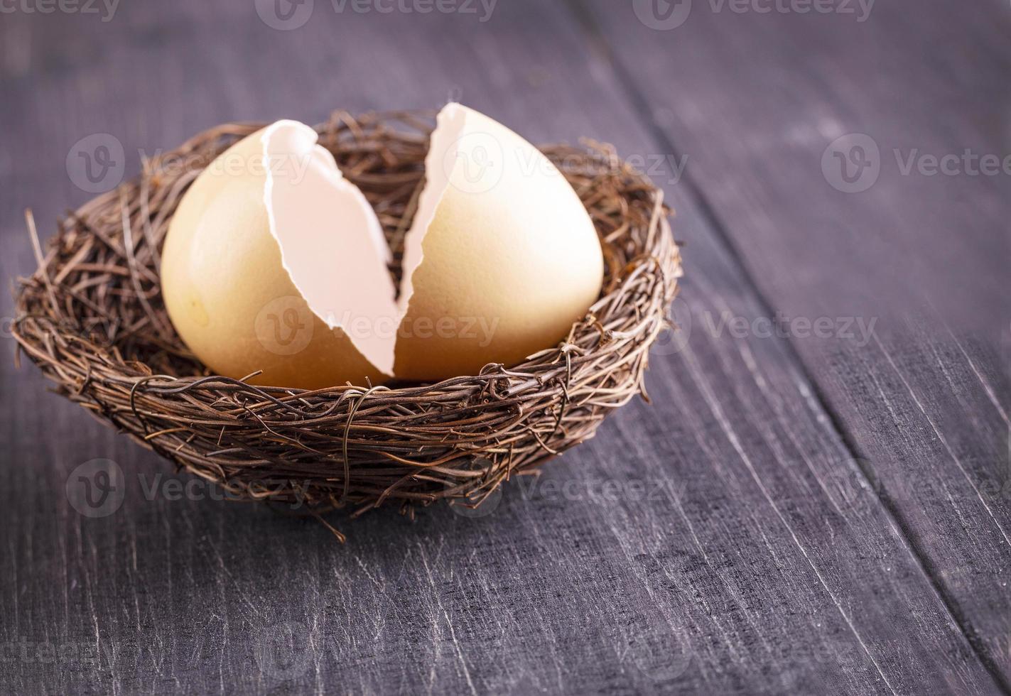 The broken egg shells in the nest on the old wooden background. photo