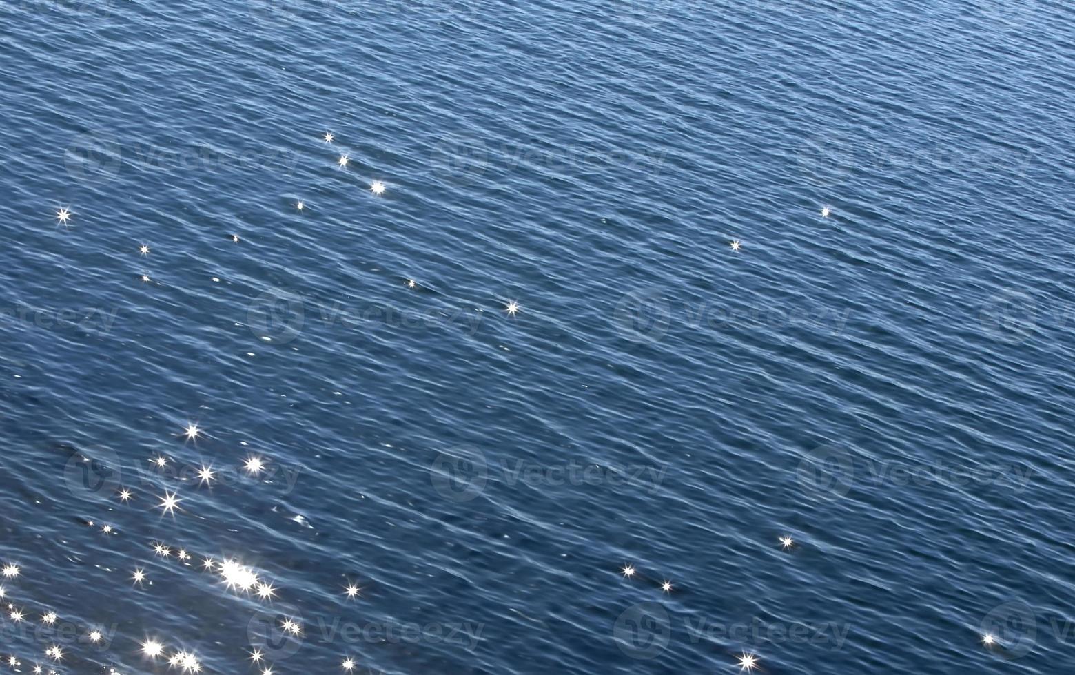 Selective focus. Texture. Ssurface of the blue sea with solar glare photo