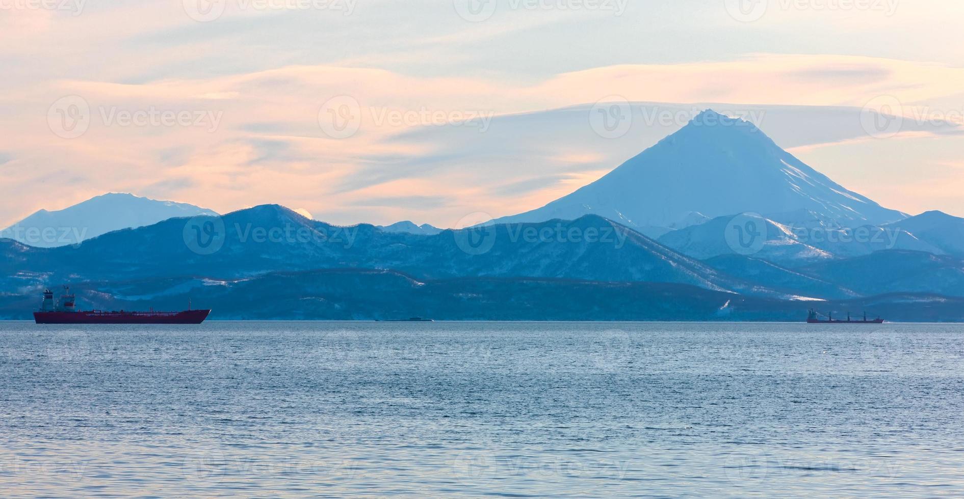 fishing boats in the Bay with the volcano on Kamchatka photo