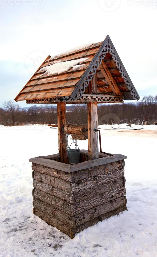 wooden well in the winter forest. Rural landscape photo