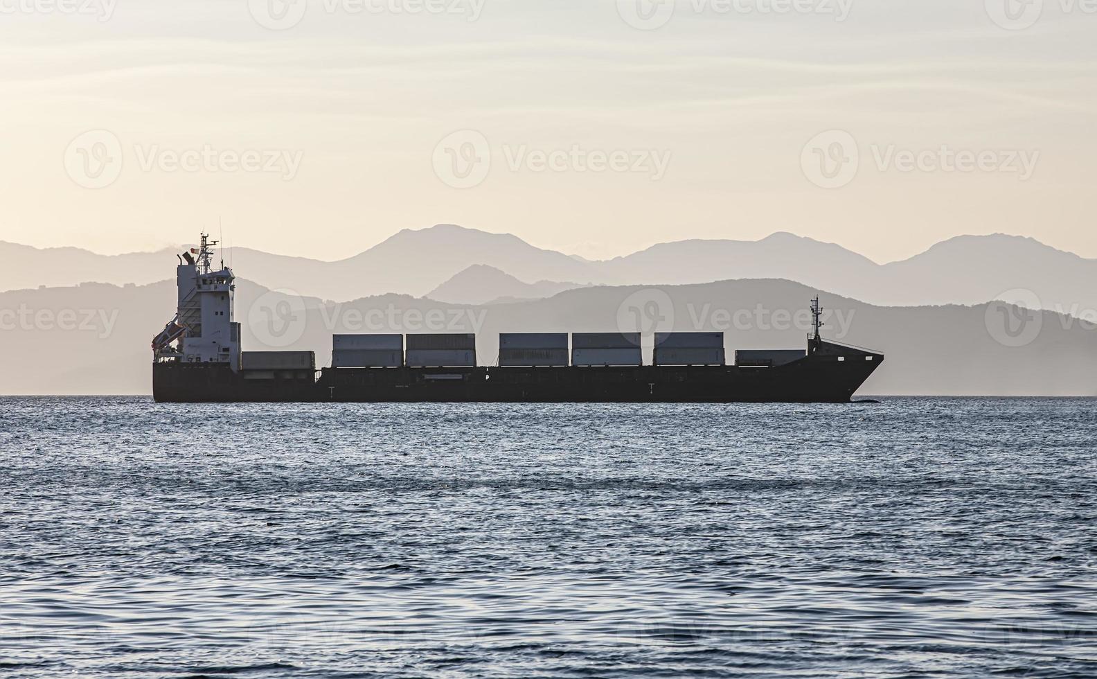 cargo ship on the background of blurred mountains photo