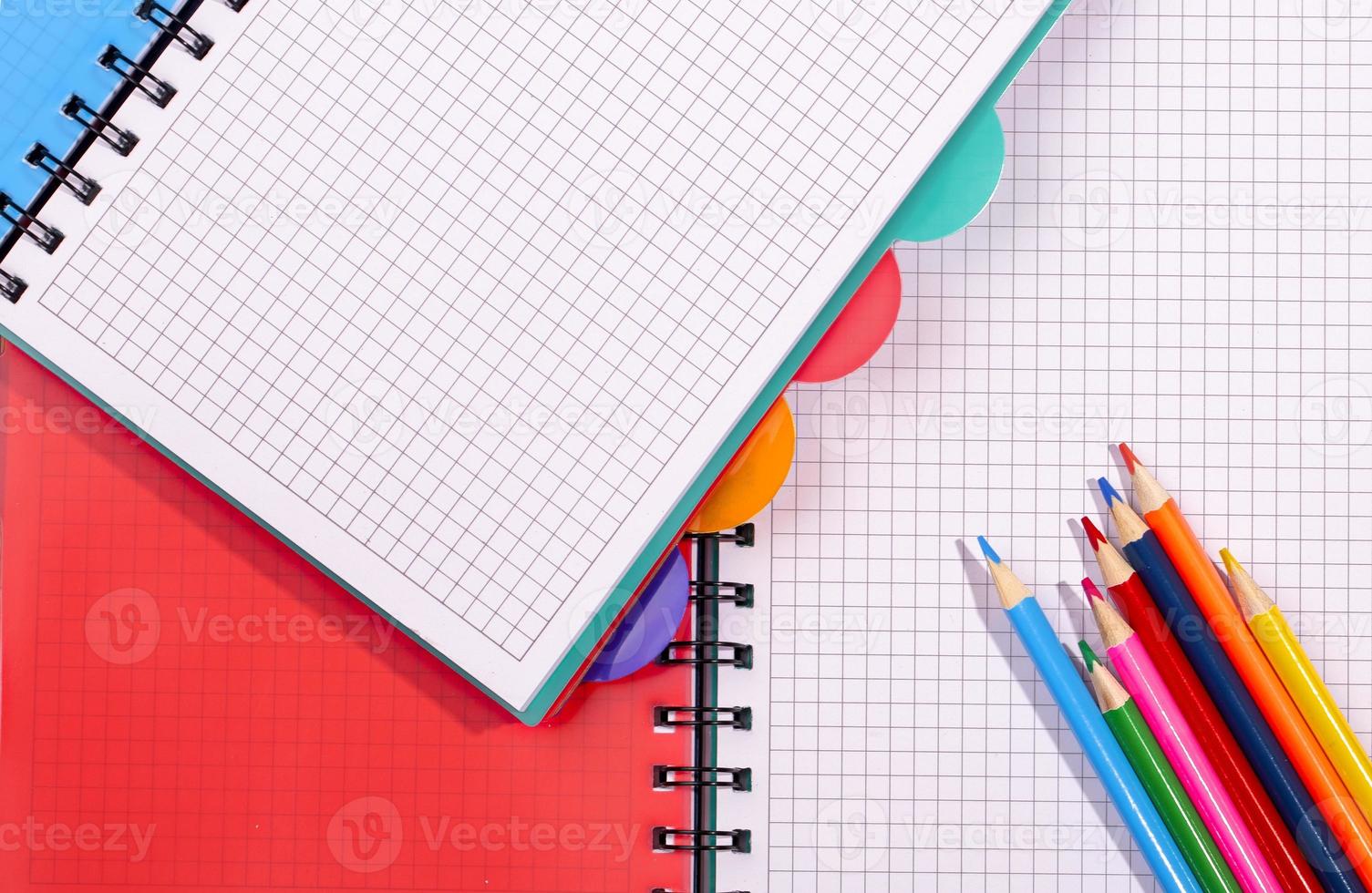 colored notebooks and pencils. Pencils on an empty notebook photo