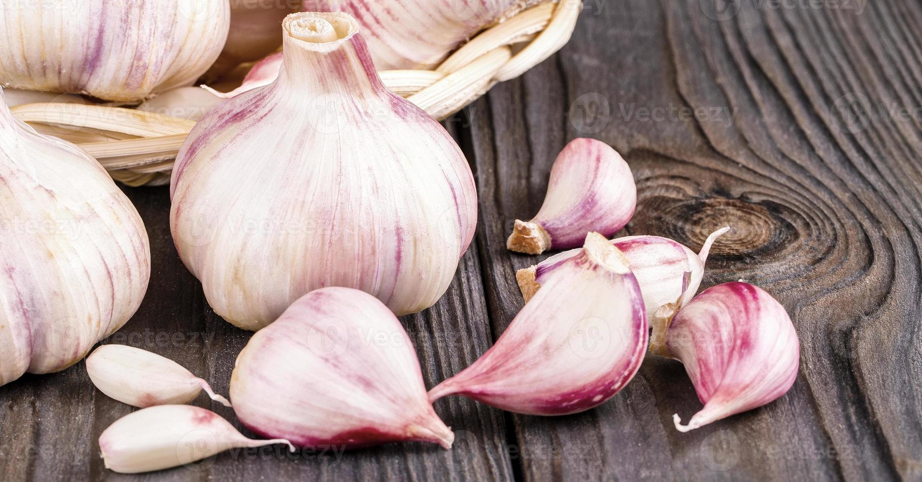 Garlic cloves and garlic bulb on a old wooden table photo